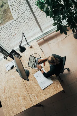 Blick von oben auf einen Arbeitsplatz, an dem gerade eine Person sitzt