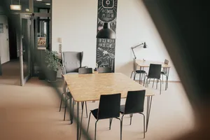 Blick in einen Raum hinein mit einem großen Tisch sowie einem kleineren Tisch im Hintergrund