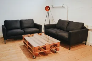 A seating area with two sofas, a floor lamp and a coffee table