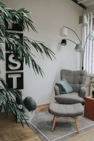 A relaxation area with a sign on the wall and an armchair with a footstool
