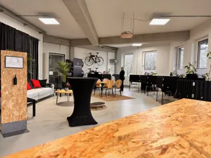 Ein Raum mit mehreren Arbeitsplätzen und einer Sofaecke.
