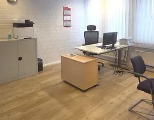 Blick ins Gästebüro mit Schreibtisch, Schrank und Drucker