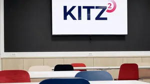 Event room with red and blue chairs and a large screen