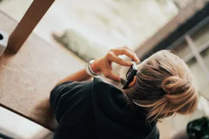 Blick im Coworking Space über die Schulter einer Frau, die gerade telefoniert.