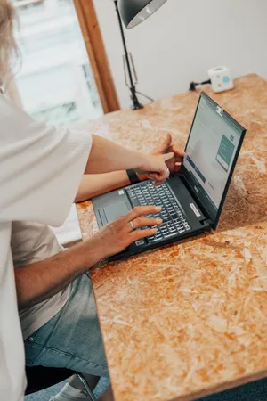 Zwei Personen schauen sich gemeinsam etwas auf einem Laptop an und zeigen darauf